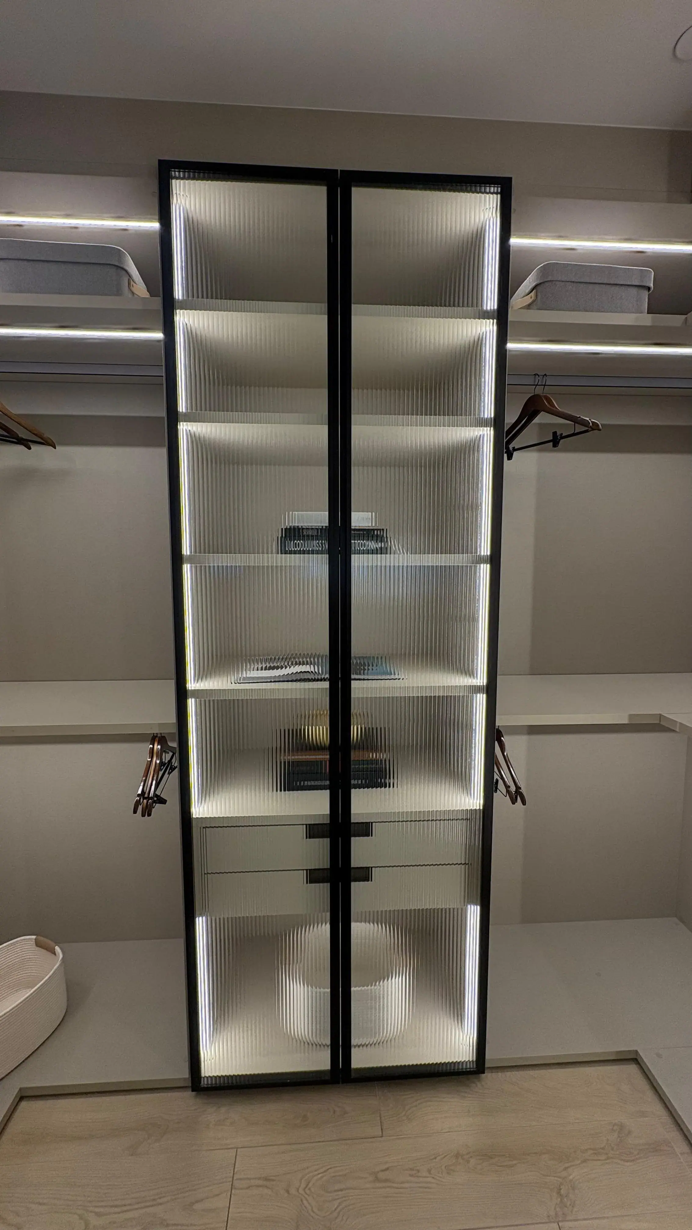 Wardrobe with fluted glass doors and lit interior