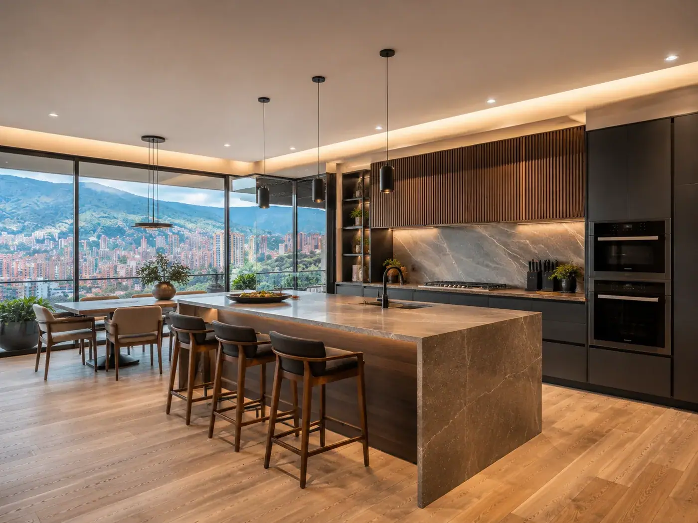 Cocina remodelada en un apartamento de Medellín: isla en piedra a cascada, frentes negros y ventanal al valle de Aburrá