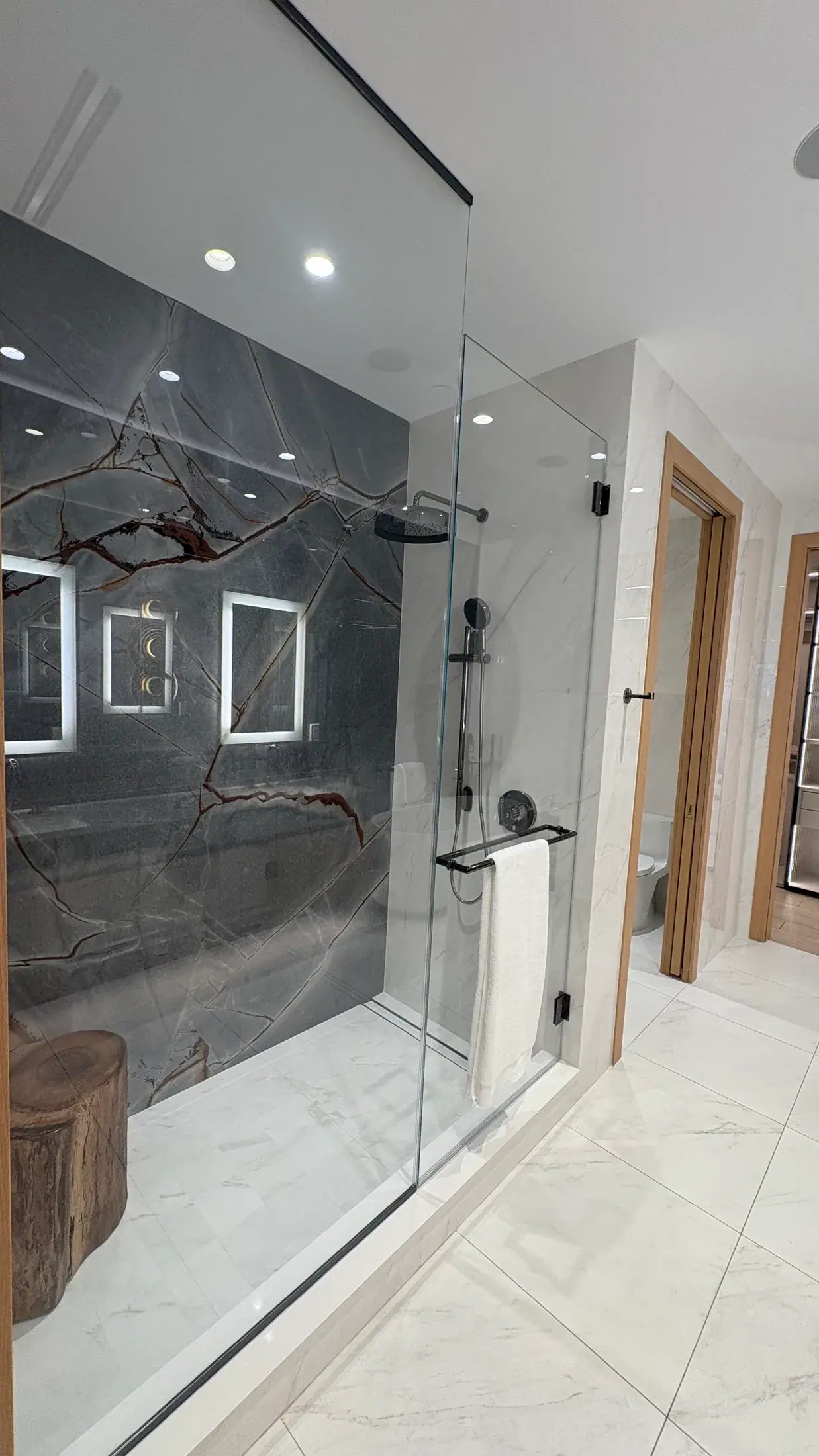Walk-in shower with the quartzite veining carried across the joint