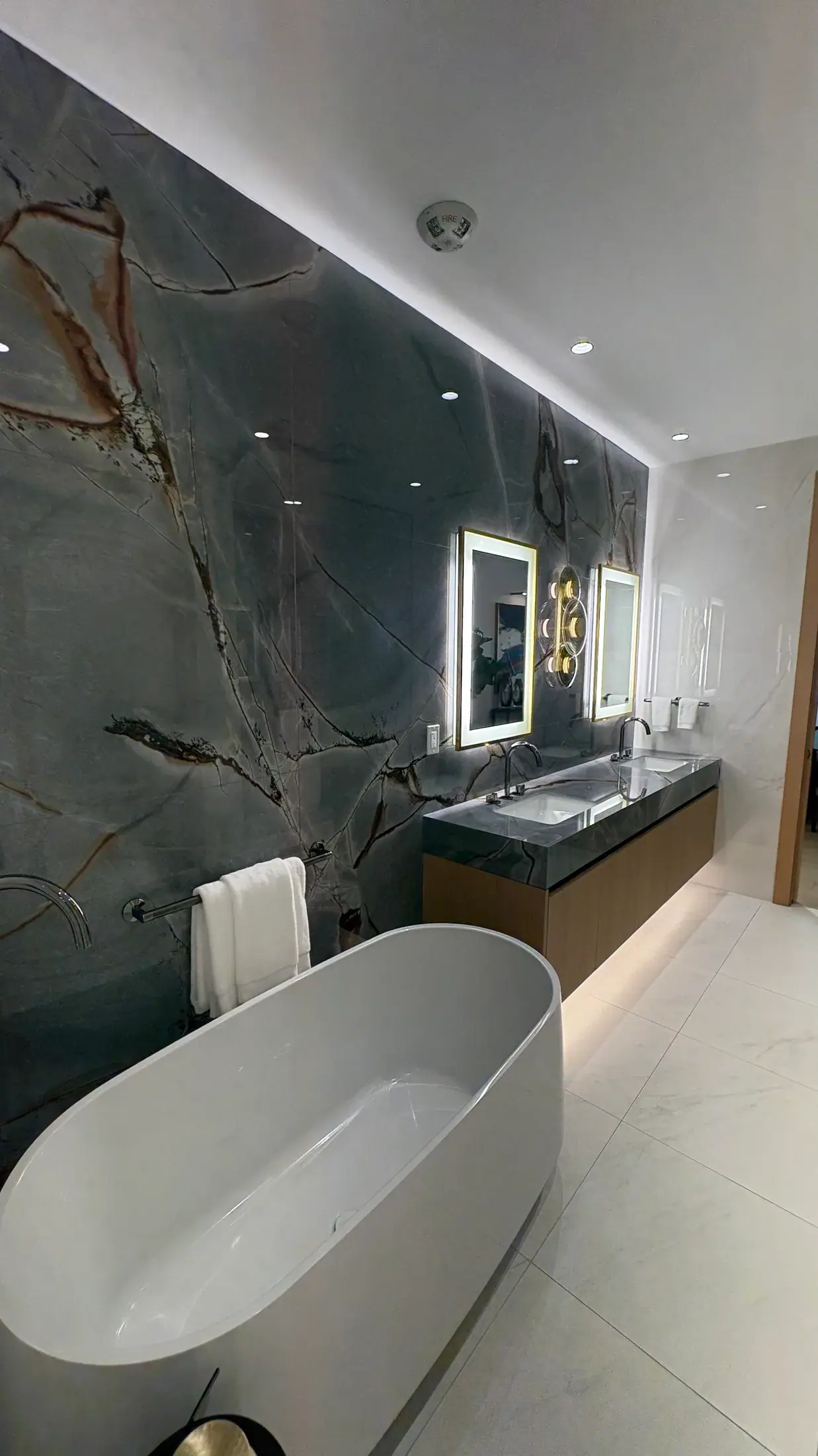 Double vanity against a full-height quartzite wall