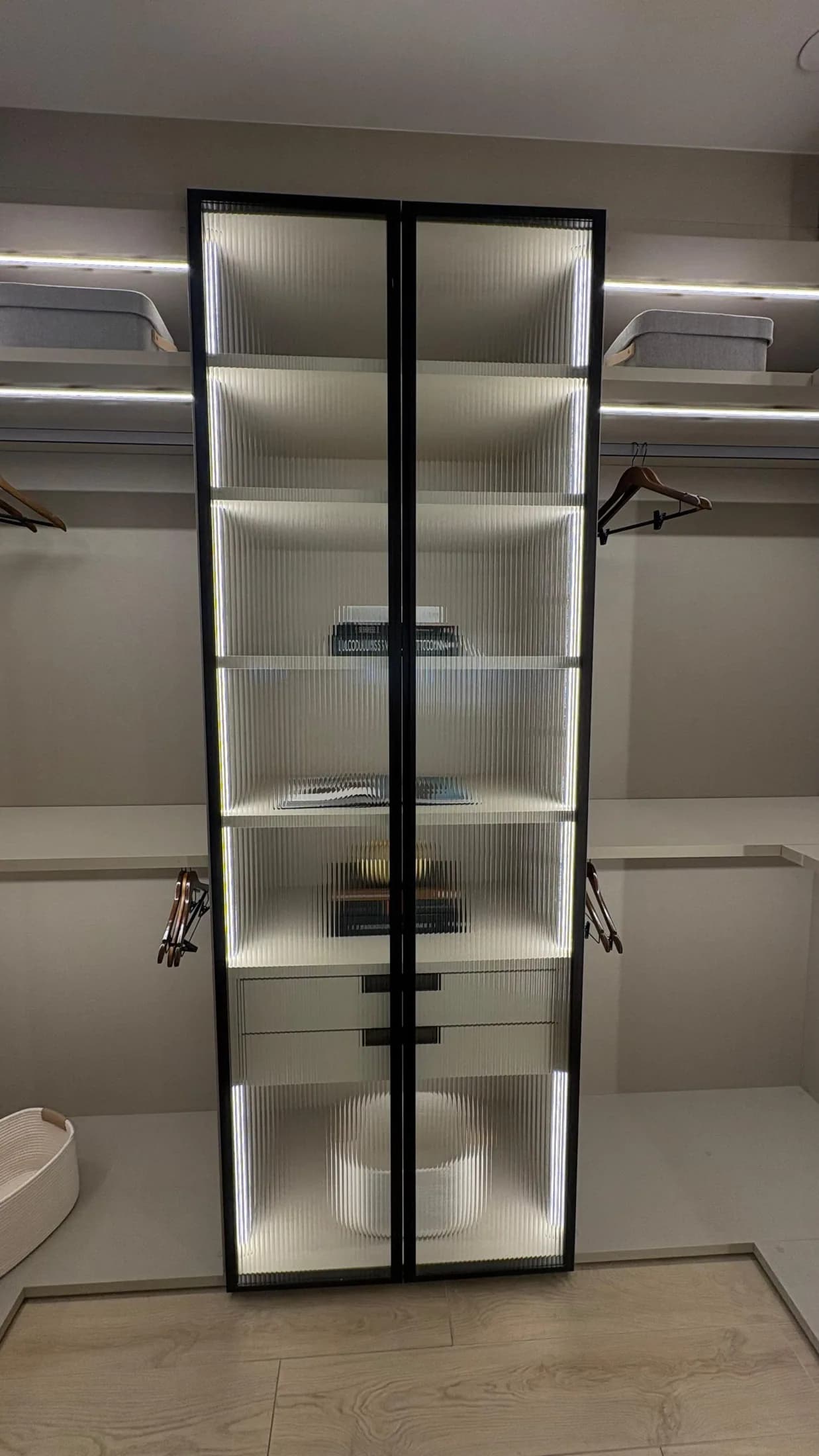Estantería expositora iluminada en un vestidor a medida
